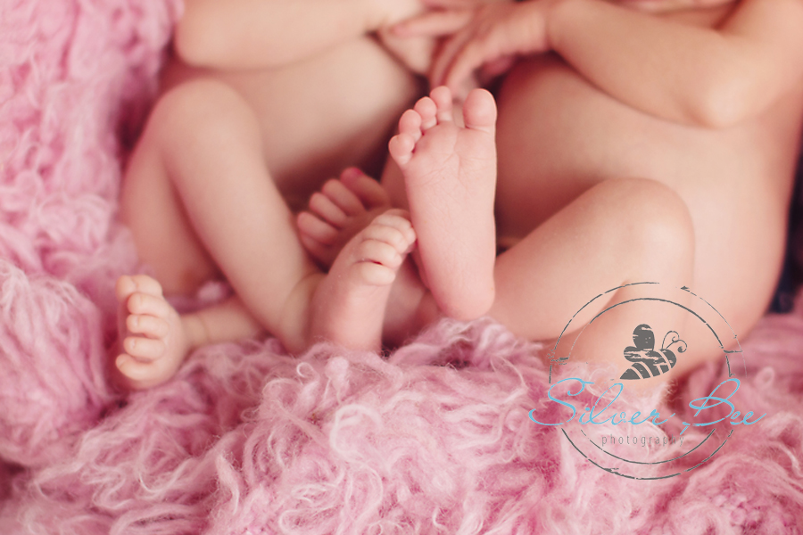 Identical twin newborn girl toes on pink flokati rug Austin Texas