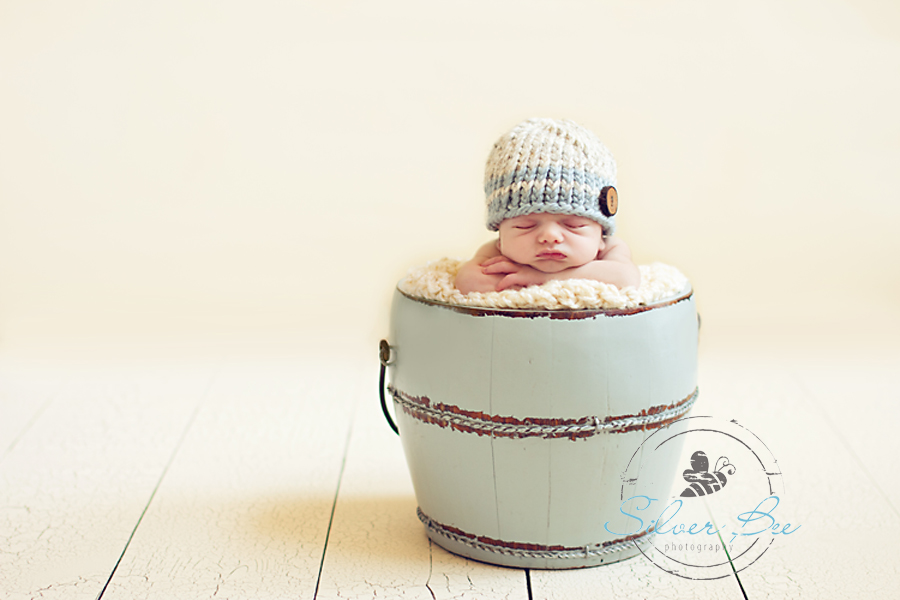 10 day old newborn boy in antique bucket with striped wool hat in Ausin Texas.