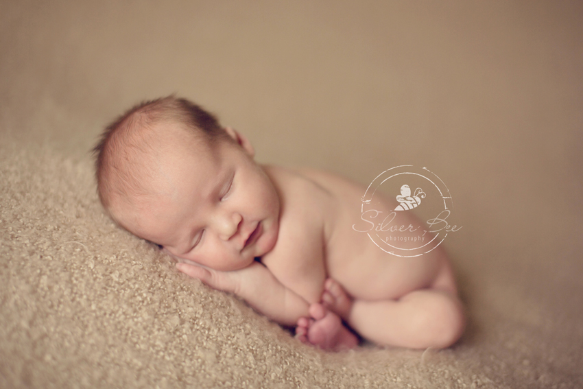Sleeping newborn baby for photography session on mohair blanket.