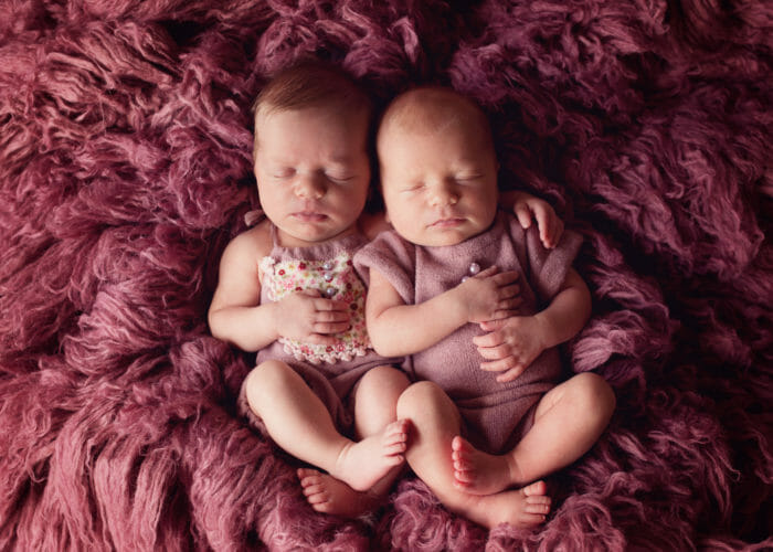 Twin baby girls in hugging pose with pink flokati rug | Austin Photograperh Silver Bee Photography