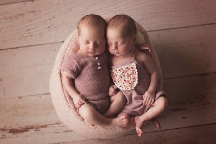 Twin newborn girls posing in a posing puff | Silver Bee Photography