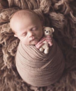 Newborn pose holding a tiny teddy bear | Silver Bee Photography