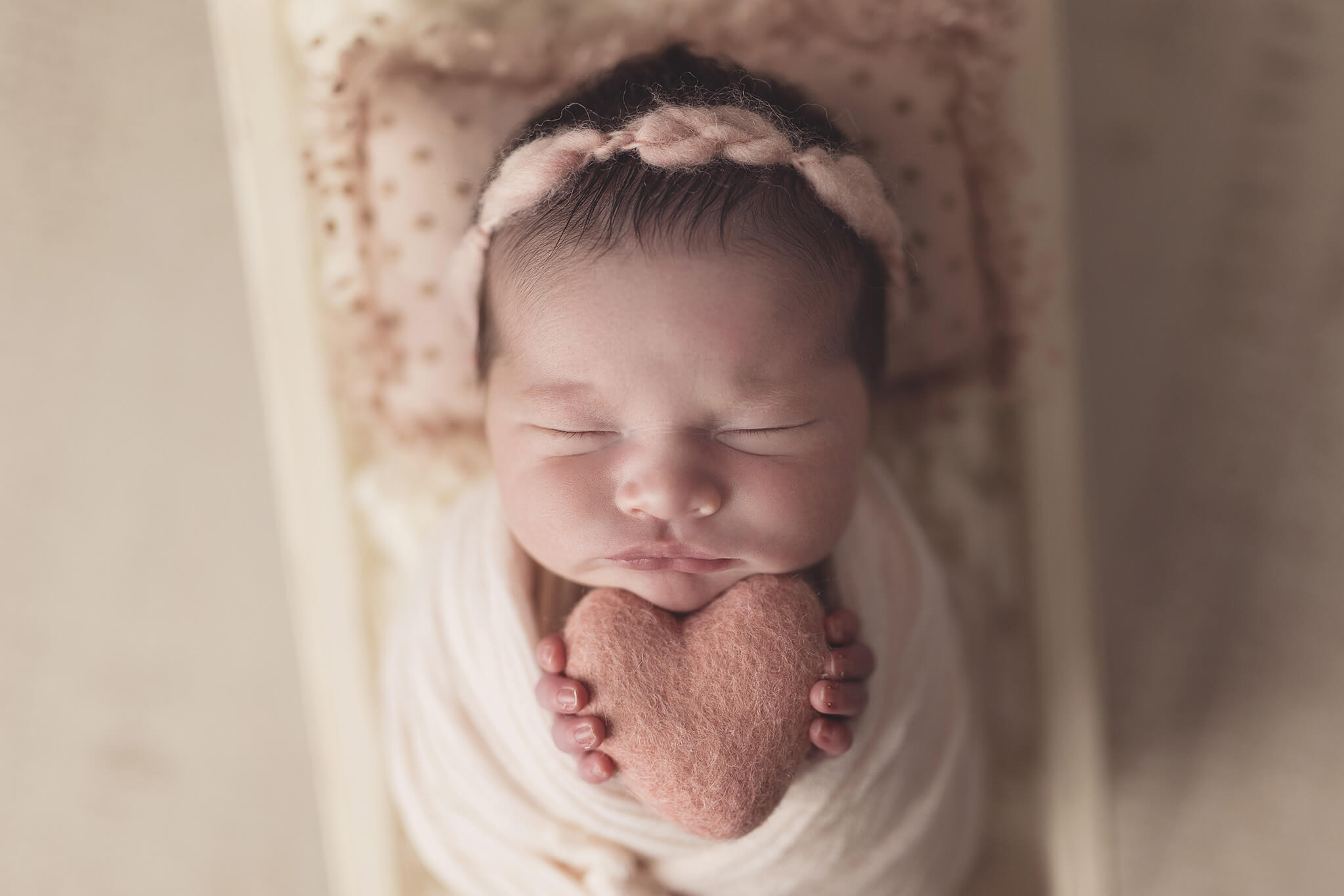 newborn holding felt heart with felt headband