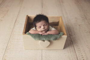 Newborn baby in a heat box prop